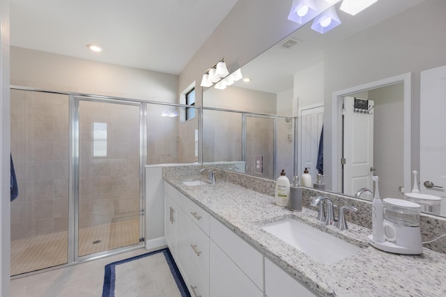 bathroom with tile patterned flooring, vanity, and an enclosed shower