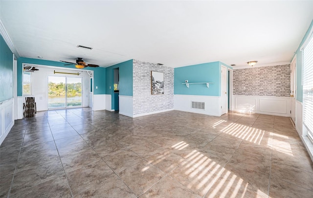 empty room with ceiling fan and brick wall