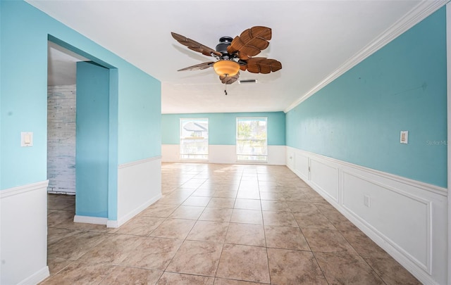 tiled spare room with ceiling fan and ornamental molding