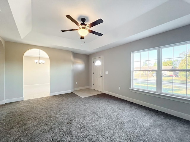 entrance foyer featuring carpet, ceiling fan with notable chandelier, and a tray ceiling