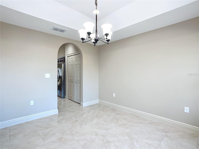 empty room featuring an inviting chandelier