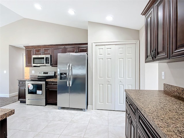 kitchen with dark brown cabinets, stainless steel appliances, vaulted ceiling, and light tile patterned flooring