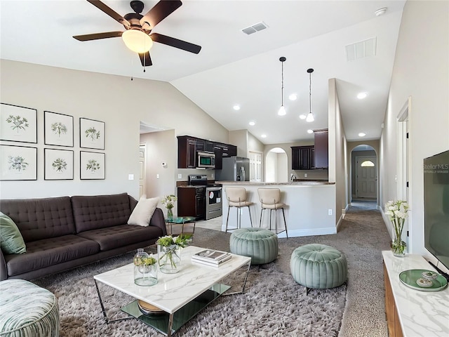 carpeted living room with ceiling fan and vaulted ceiling