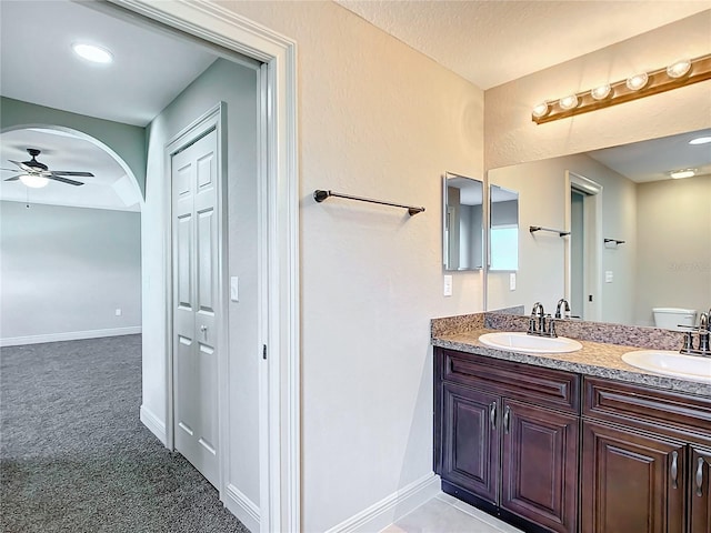 bathroom with vanity, toilet, and ceiling fan