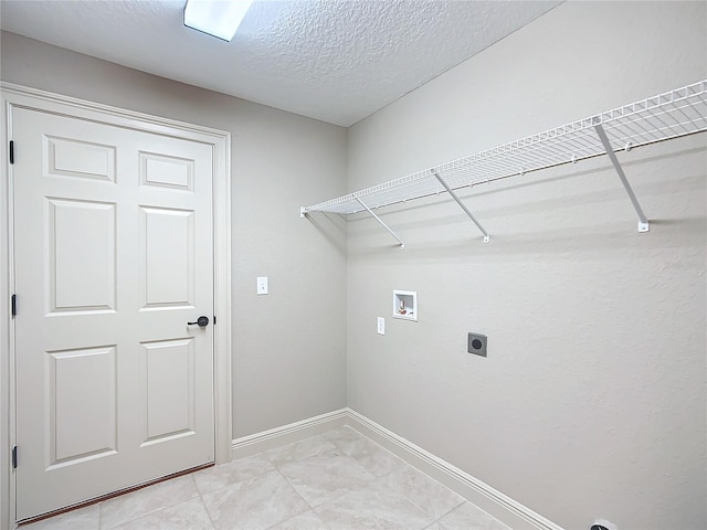 washroom with hookup for an electric dryer, light tile patterned floors, a textured ceiling, and hookup for a washing machine