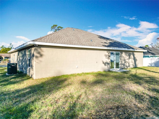 back of property featuring a lawn and central AC unit