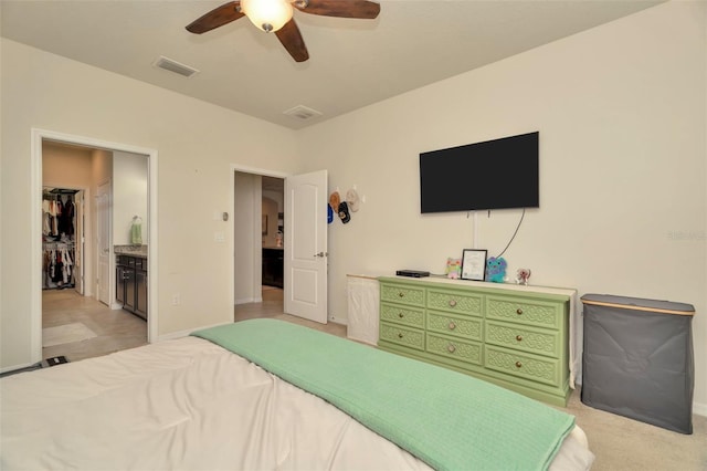 carpeted bedroom with ceiling fan and connected bathroom