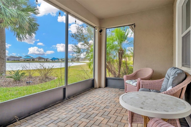 sunroom / solarium featuring a water view