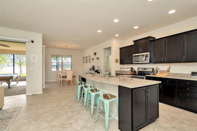 kitchen with appliances with stainless steel finishes, a kitchen island with sink, sink, pendant lighting, and billiards