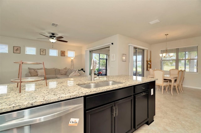 kitchen featuring dishwasher, sink, light stone counters, decorative light fixtures, and ceiling fan with notable chandelier