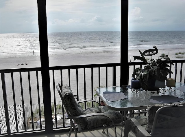 balcony featuring a water view and a view of the beach