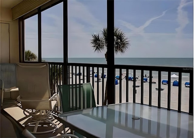 balcony featuring a water view and a beach view