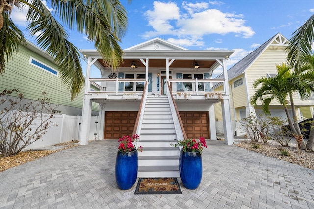 coastal inspired home with a porch and ceiling fan