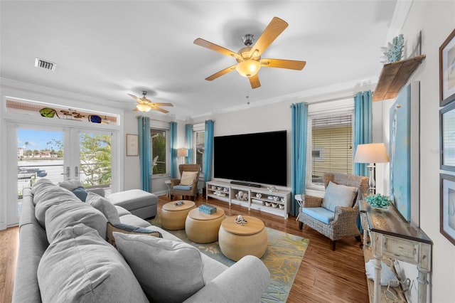 living room featuring ceiling fan, light wood-type flooring, crown molding, and french doors