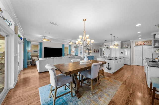 dining area featuring ceiling fan with notable chandelier, light hardwood / wood-style flooring, and ornamental molding