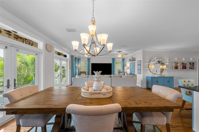 dining room featuring french doors, light hardwood / wood-style flooring, ceiling fan with notable chandelier, and ornamental molding