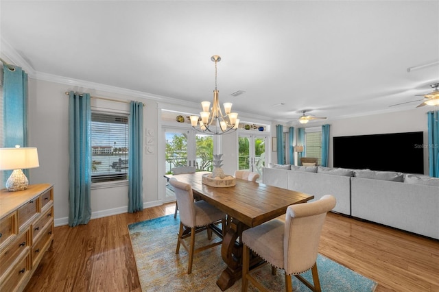 dining space with french doors, ceiling fan with notable chandelier, ornamental molding, and wood-type flooring