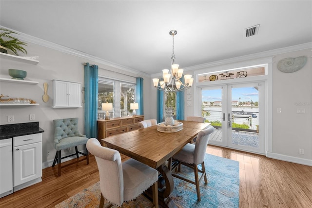 dining space with a wealth of natural light, french doors, wood-type flooring, and ornamental molding