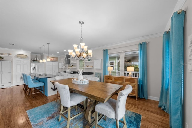 dining space featuring a chandelier, wood-type flooring, and ornamental molding