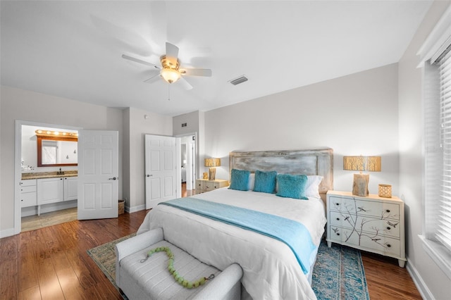 bedroom featuring ceiling fan, dark hardwood / wood-style flooring, sink, and connected bathroom