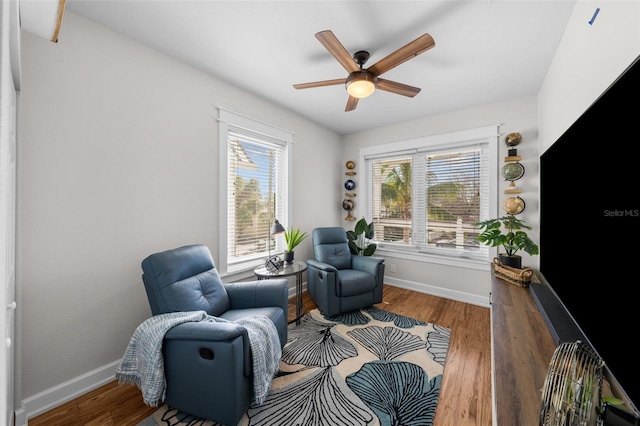 sitting room with hardwood / wood-style floors and ceiling fan