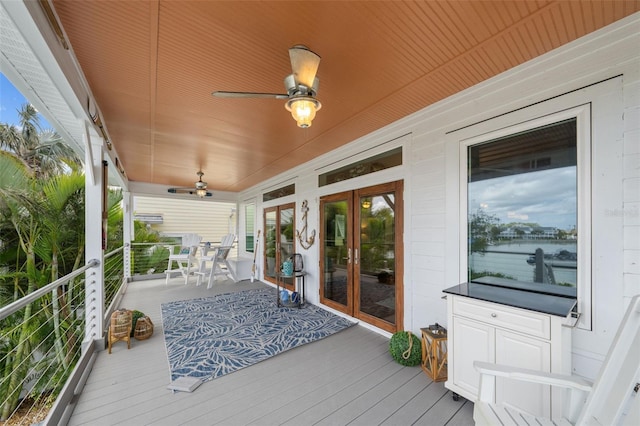 wooden deck with covered porch, french doors, and ceiling fan