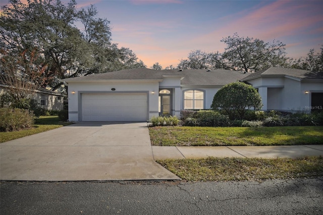 ranch-style home featuring a yard and a garage