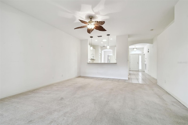 unfurnished living room with light colored carpet and ceiling fan