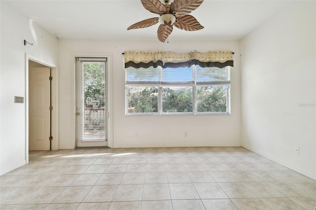 spare room with ceiling fan and light tile patterned floors