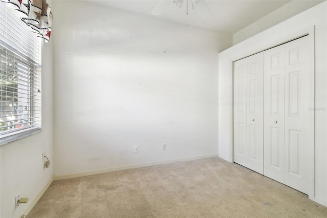 unfurnished bedroom with ceiling fan, light colored carpet, and a closet