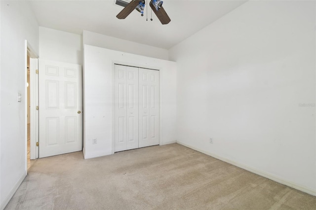 unfurnished bedroom featuring ceiling fan, light carpet, and a closet