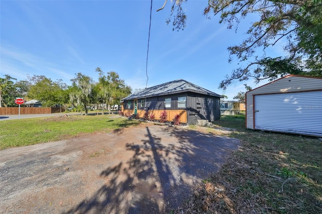 view of front facade with a garage, an outbuilding, and a front yard