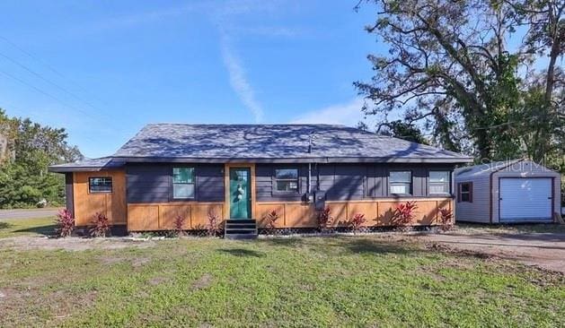 view of front of home featuring a front lawn and a storage unit