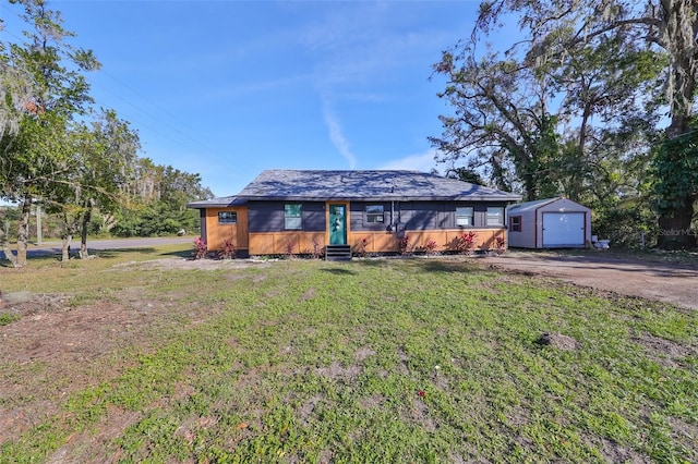 ranch-style house featuring an outbuilding, a front yard, and a garage