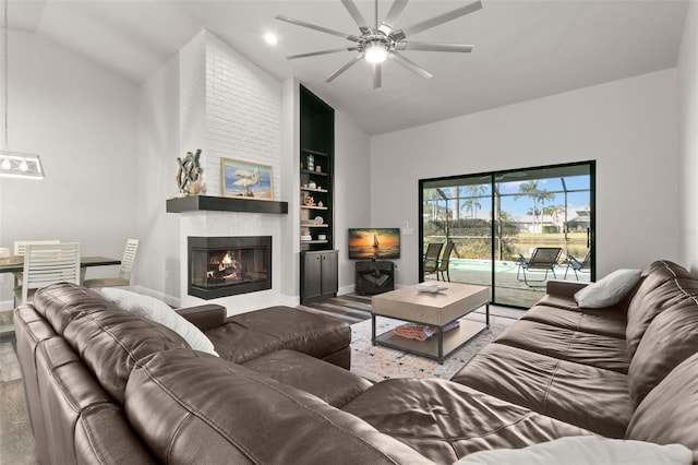 living room featuring built in shelves, a large fireplace, light hardwood / wood-style flooring, and lofted ceiling