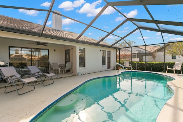 view of pool featuring ceiling fan, a patio, and glass enclosure