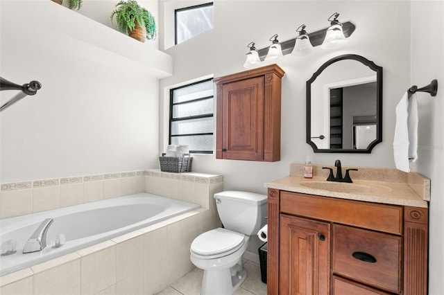 bathroom with tile patterned flooring, vanity, tiled bath, and toilet