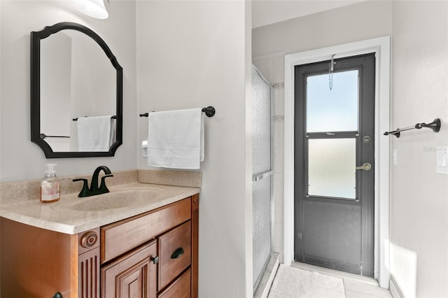 bathroom with tile patterned flooring, vanity, a healthy amount of sunlight, and an enclosed shower