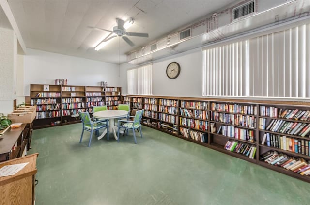 interior space featuring ceiling fan and concrete flooring