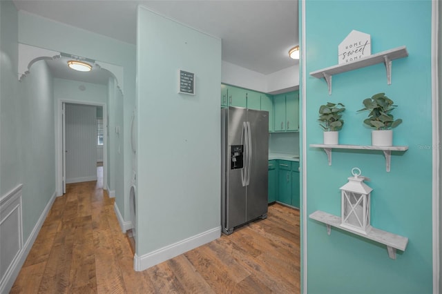 kitchen featuring stainless steel refrigerator with ice dispenser, dark wood-type flooring, and green cabinetry