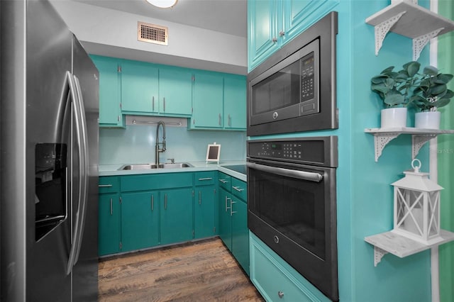 kitchen with dark wood-type flooring, appliances with stainless steel finishes, and sink