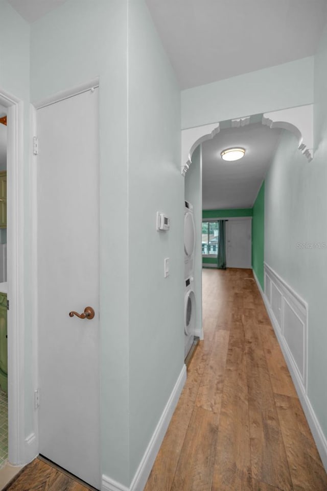 hall featuring stacked washer and clothes dryer and light hardwood / wood-style floors