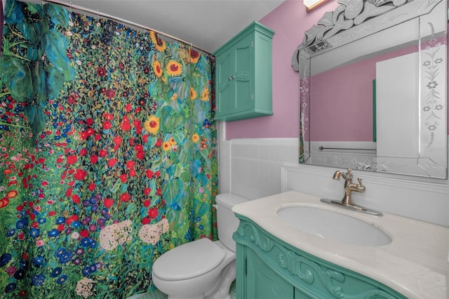 bathroom featuring tile walls, vanity, and toilet