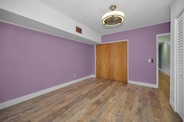 unfurnished bedroom with wood-type flooring and a closet