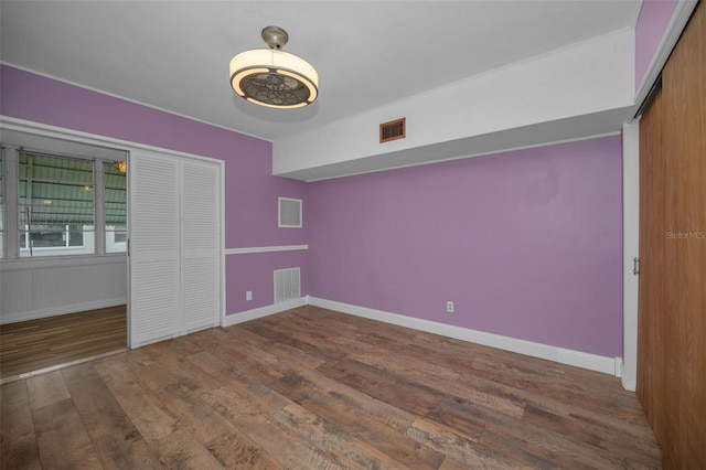 unfurnished bedroom featuring dark hardwood / wood-style floors and a closet