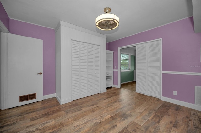 unfurnished bedroom featuring ornamental molding and dark hardwood / wood-style flooring