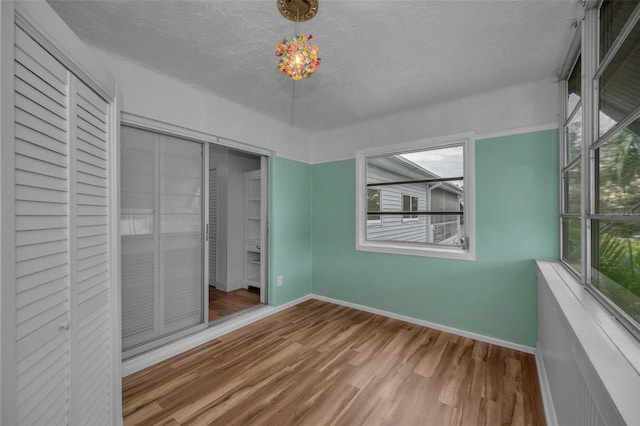 unfurnished bedroom featuring hardwood / wood-style flooring and a textured ceiling