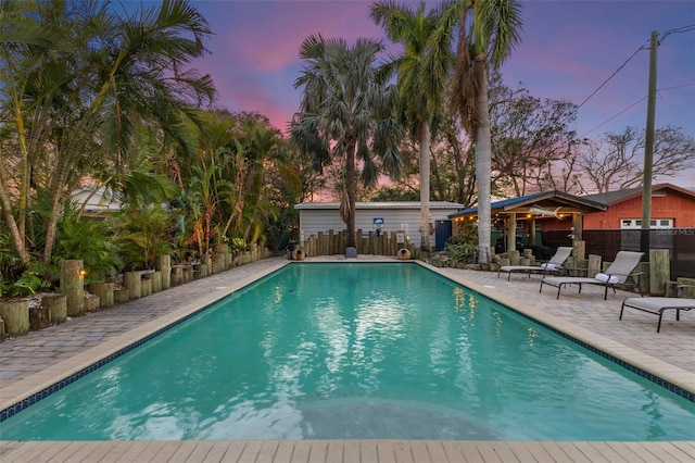 pool at dusk with a patio