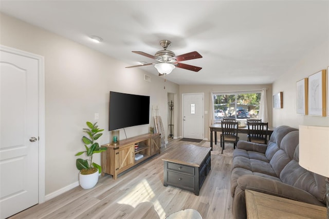 living room featuring light hardwood / wood-style flooring and ceiling fan