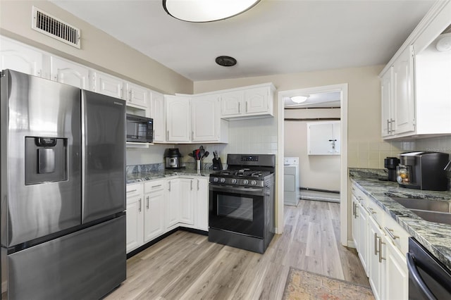 kitchen with light hardwood / wood-style flooring, white cabinets, and appliances with stainless steel finishes